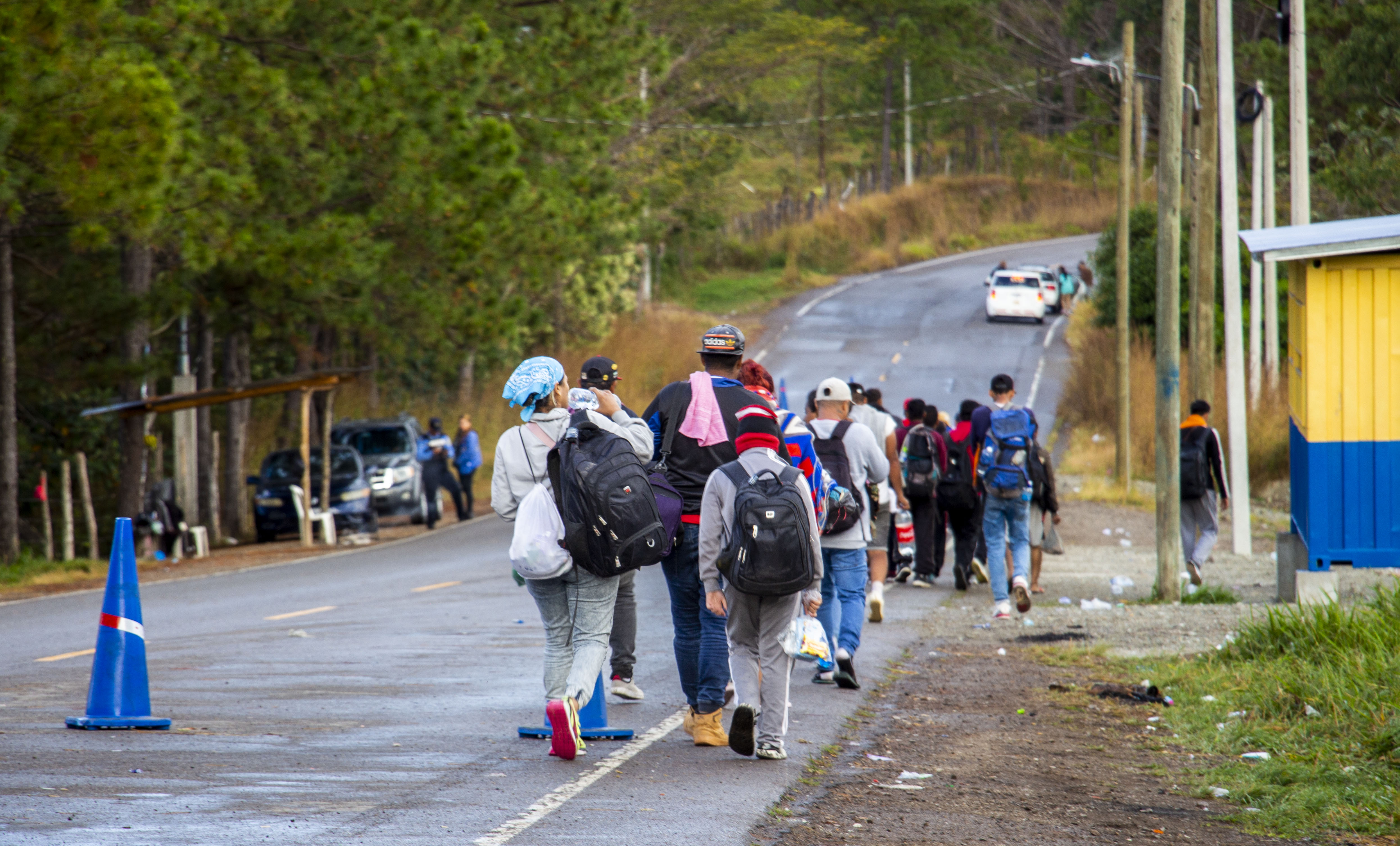 Grupo de personas migrantes caminan por una carretera